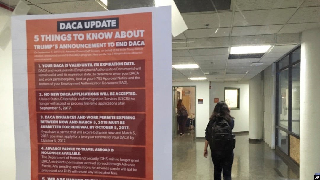 A student walks past a tip sheet for Deferred Action for Childhood Arrivals recipients who fear deportation that is taped to a window on the University of California, Berkeley campus in Berkeley, California, Sept. 7, 2017. Colleges and universities nationwide are stepping up efforts to help the students who are often called "Dreamers," after the Trump administration announced plans last week to end that federal program protecting immigrants brought to the U.S. illegally as children.