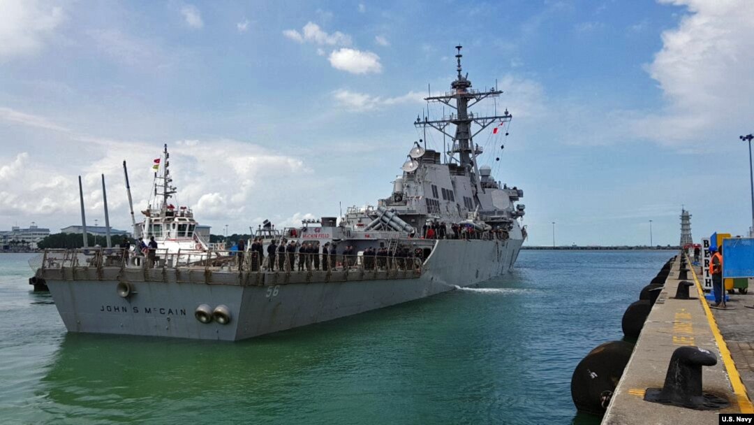 The guided-missile destroyer USS John S. McCain (DDG 56) arrives pier side at Changi Naval Base, Republic of Singapore following a collision with the merchant vessel Alnic MC while underway east of the Straits of Malacca and Singapore.