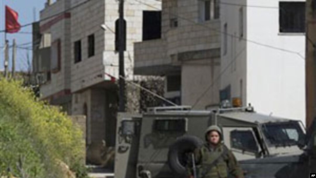 Israeli troops operate in the West Bank village of Awarta, after five people were killed in the nearby Jewish settlement of Itamar, March 12, 2011