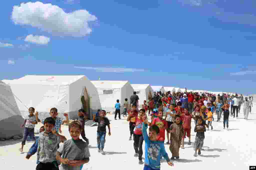 Displaced Syrians take part in a protest against the regime and its ally Russia at a camp for displaced people in Kafr Lusin near the Bab al-Hawa border crossing with Turkey in Syria's northern Idlib province.