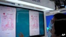 在中國北京的一個貿易展覽會上，參觀者在看電子人民幣（2021年9月5日）。