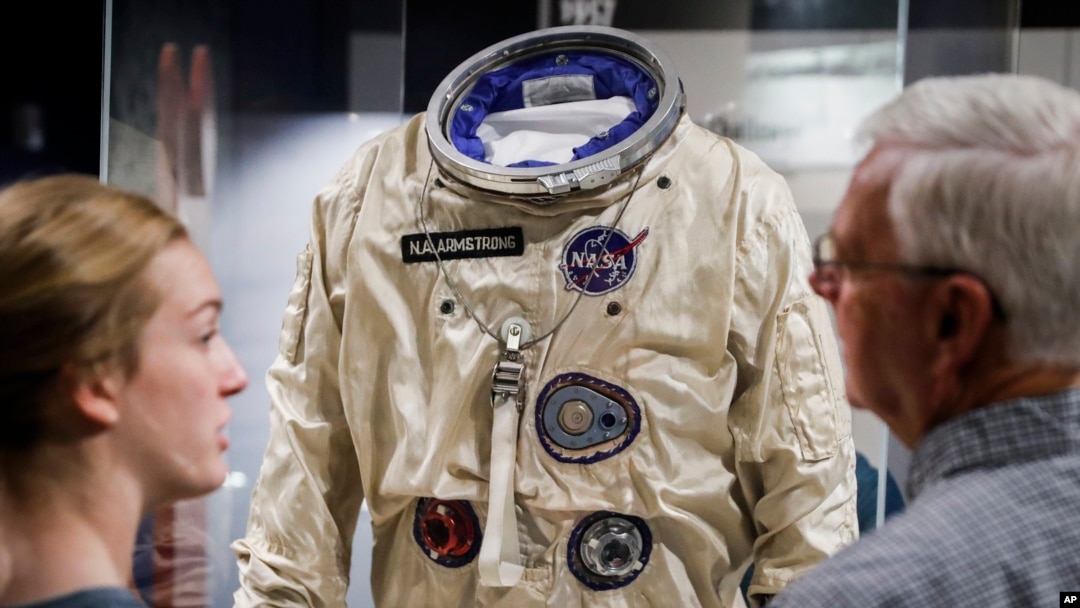 Visitors stand before the spacesuit worm by astronaut Neil Armstrong that was used on his Gemini VIII mission at the Armstrong Air & Space Museum, Wednesday, June 26, 2019, in Wapakoneta, Ohio. 