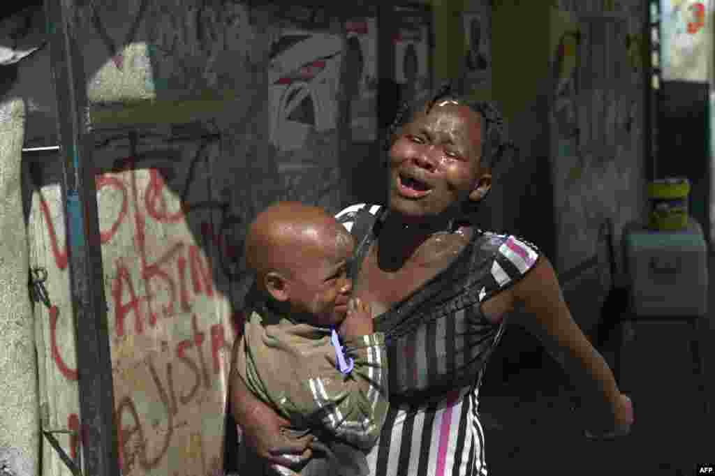 A woman reacts to tear gas fired by the Haitian National Police during clashes with supporters of presidential candidate Maryse Narcisse, in the neighborhood of La Saline, in the capital Port-au-Prince.