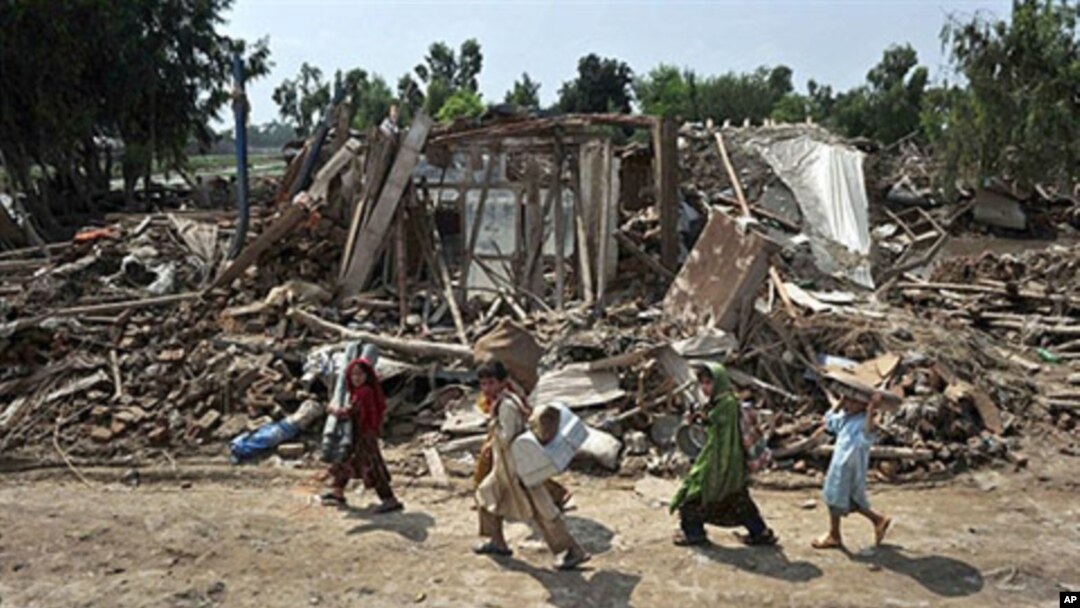 Afghan refugees evacuating a flood devastated area of Azakhel Camp near Nowshera, Pakistan, 16 Aug 2010