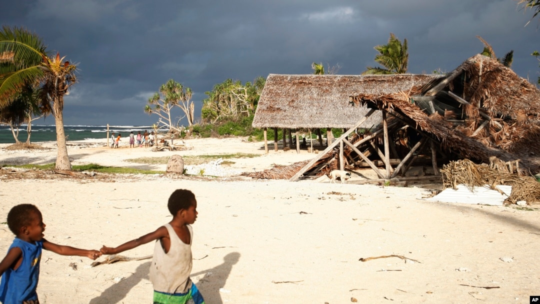 FILE - Children play on the beach in the town of Takara, on Efate Island, Vanuatu, May 30, 2015. The town was damaged in March of that year during Cyclone Pam. Many people in the town considered rebuilding on higher ground to escape what they thought were the ongoing effects of climate change. 