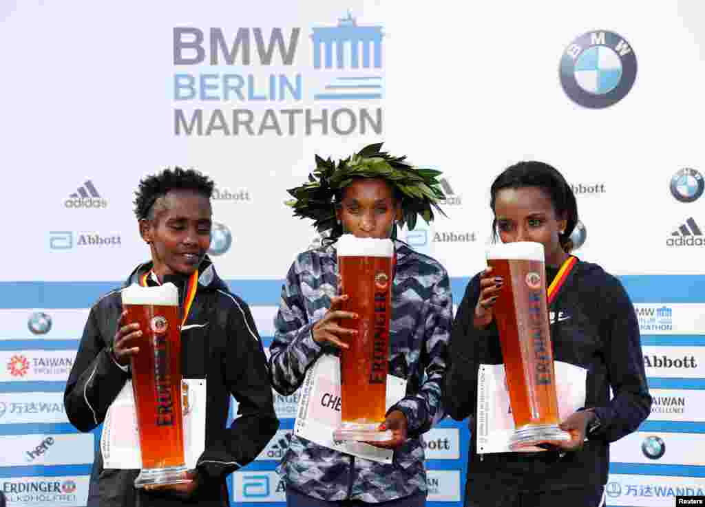 Kenya's Gladys Cherono Kiprono (C) poses after winning the Berlin Marathon alongside second placed Ruti Aga (L) of Ethiopia and third placed Tirunesh Dibaba also of Ethopia (R) in Berlin, Germany.