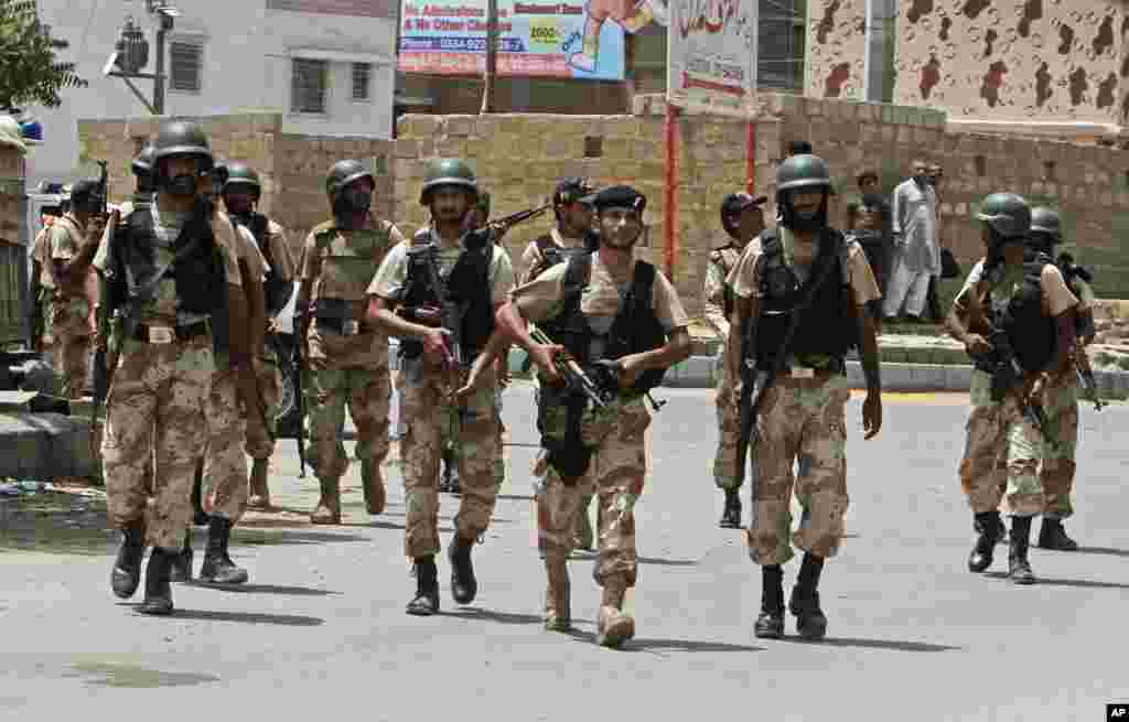Security personnel inspect the site around a training center after gunmen attacked the facility in Karachi, Pakistan, June 10, 2014.