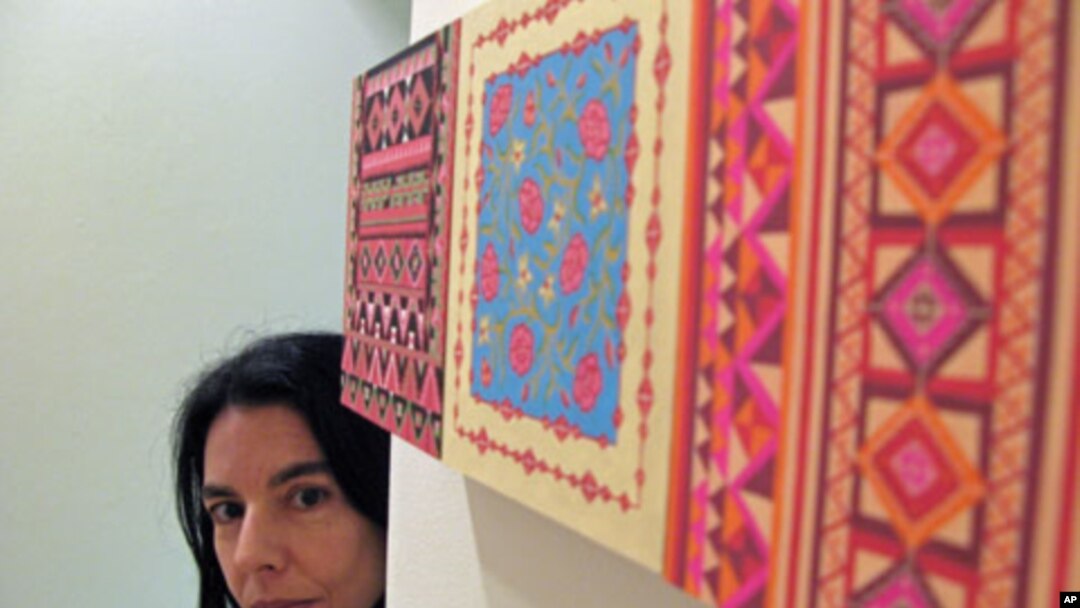 Artist Helen Zughaib takes a peek around her piece 'Another Wall,' June 2011