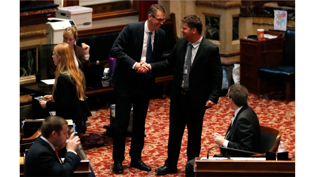 FILE - Sen. Randy Feenstra, R-Hull, left, talks with Sen. Rick Bertrand, R-Sioux City, following debate on the tax bill in the Iowa Senate, May 5, 2018, at the Statehouse in Des Moines.