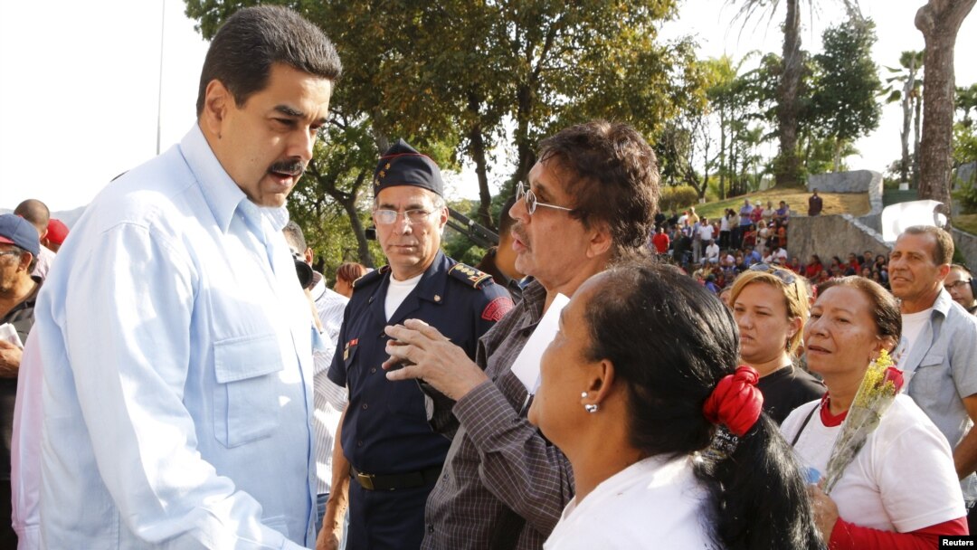 Venezuela's President Nicolas Maduro (L) talks with supporters during a mass at Miraflores Palace in Caracas, in this handout picture provided by Miraflores Palace, April 11, 2016. 