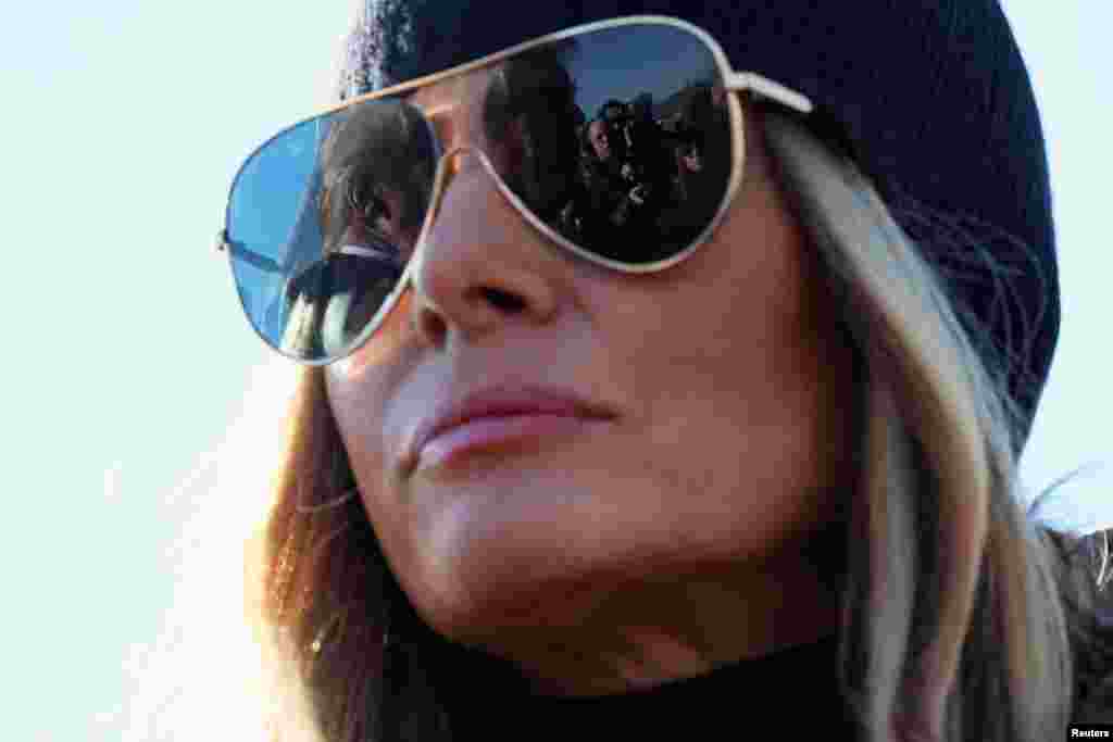 U.S. President Donald Trump is reflected in first lady Melania Trump's sunglasses as he speaks to the media, as they arrive to assess recovery efforts and tour areas devastated by Hurricane Helene, in Asheville, North Carolina.