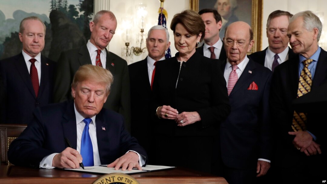 President Donald Trump signs a presidential memorandum imposing tariffs and investment restrictions on China in the Diplomatic Reception Room of the White House, March 22, 2018, in Washington. 
