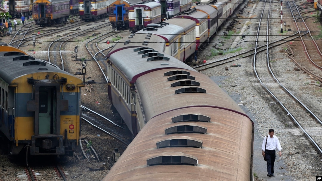 FILE - In this photo taken July 10, 2014, a man walks along rail tracks in Bangkok. Thailand's military government has approved a massive budget to upgrade the country's railways including high-speed rails that would eventually link with China. 