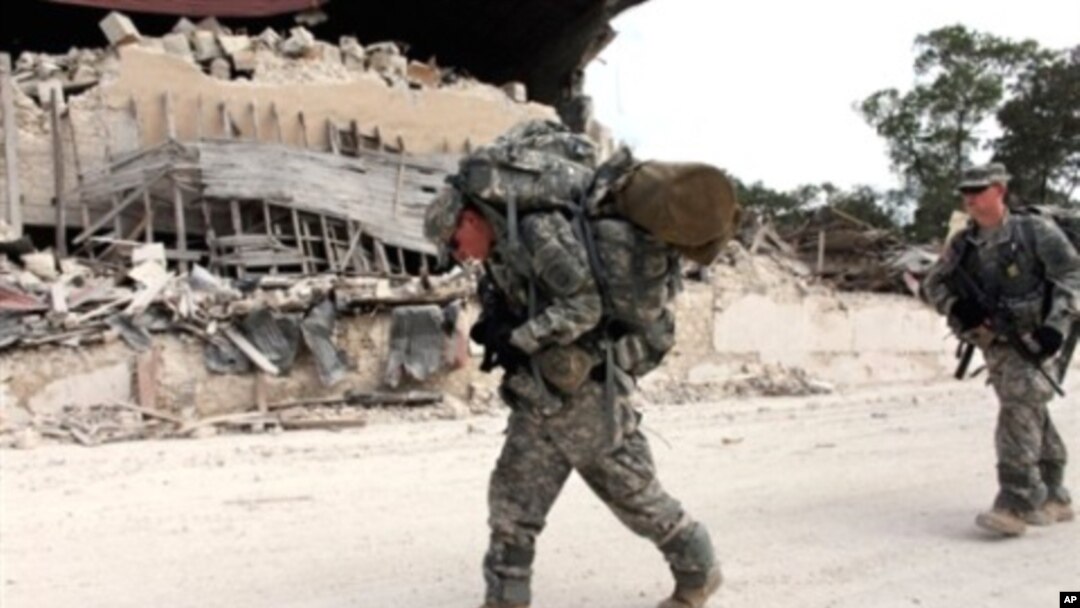 US soldiers of the 82nd Airborne Division walk in streets after leaving the Presidential palace en route to the general hospital in downtown Port-au-Prince, 19 Jan 2010