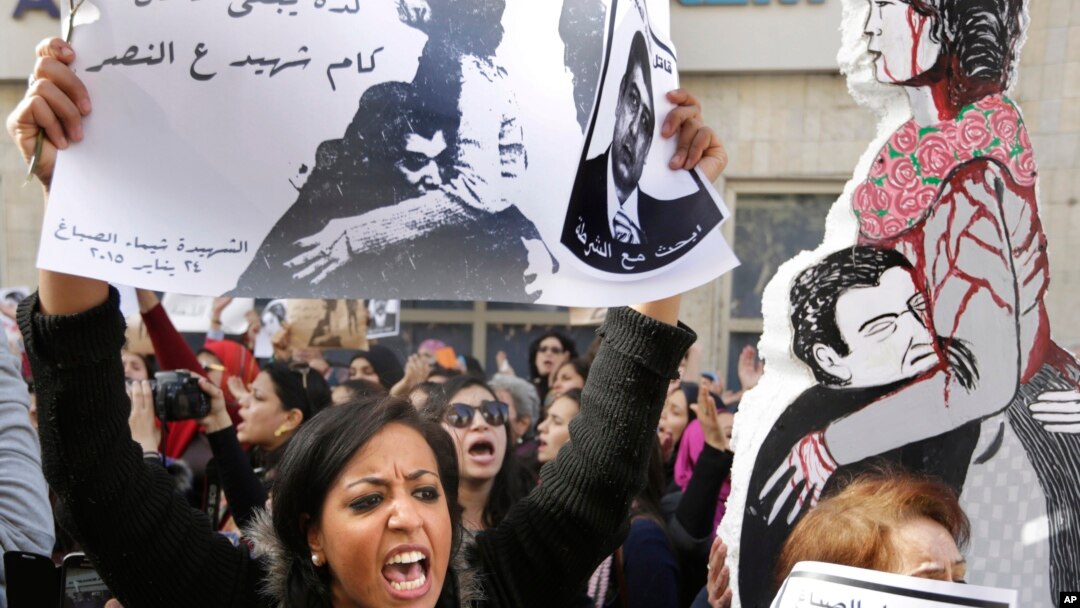 An Egyptian protester chants anti interior ministry slogans as she holds a poster of Shaimaa el-Sabagh, an activist who was shot dead at a small peaceful protest last Saturday, with Arabic that reads, " how many martyrs remaining for victory," during a wo
