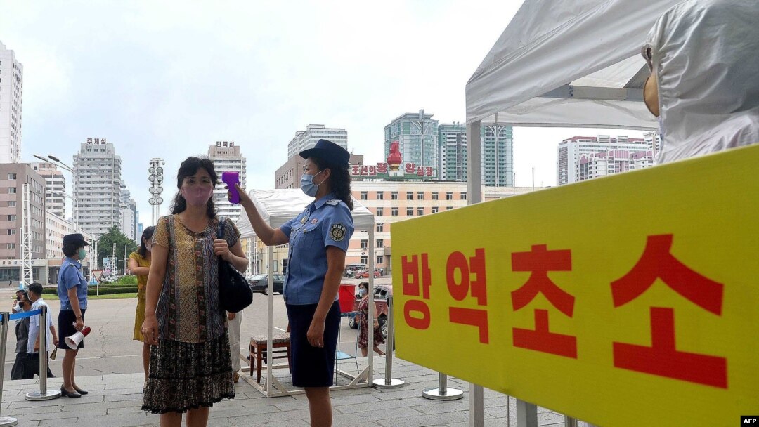 지난 2020년 9월 북한 평양역 입구에서 역무원이 신종 코로나바이러스 방역을 위해 승객들의 체온을 재고 있다. (자료사진)