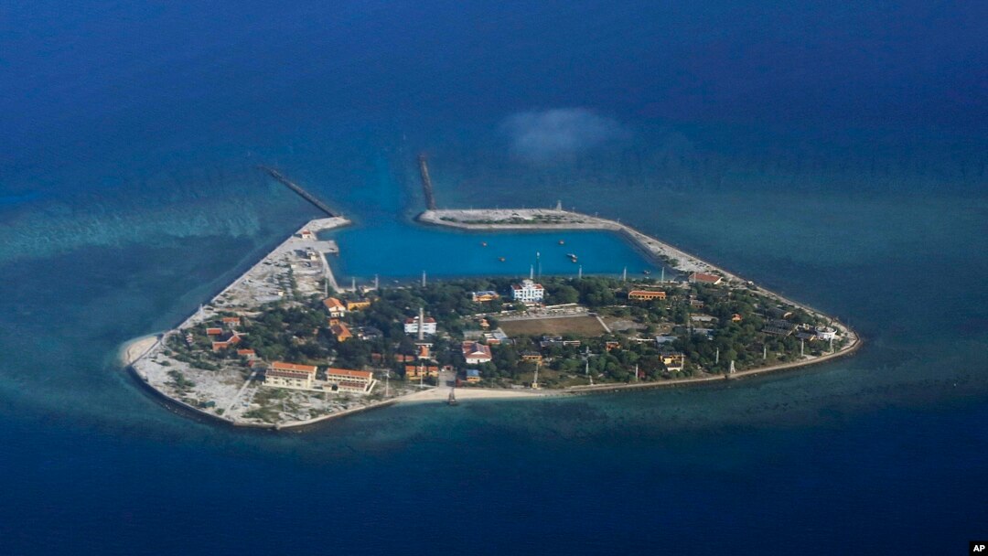 FILE - The Vietnamese-claimed Southwest Cay island in the Spratly island group is seen from a Philippine Air Force C-130 transport plane during the visit to the Philippine-claimed Thitu Island by Defense Secretary Delfin Lorenzana.