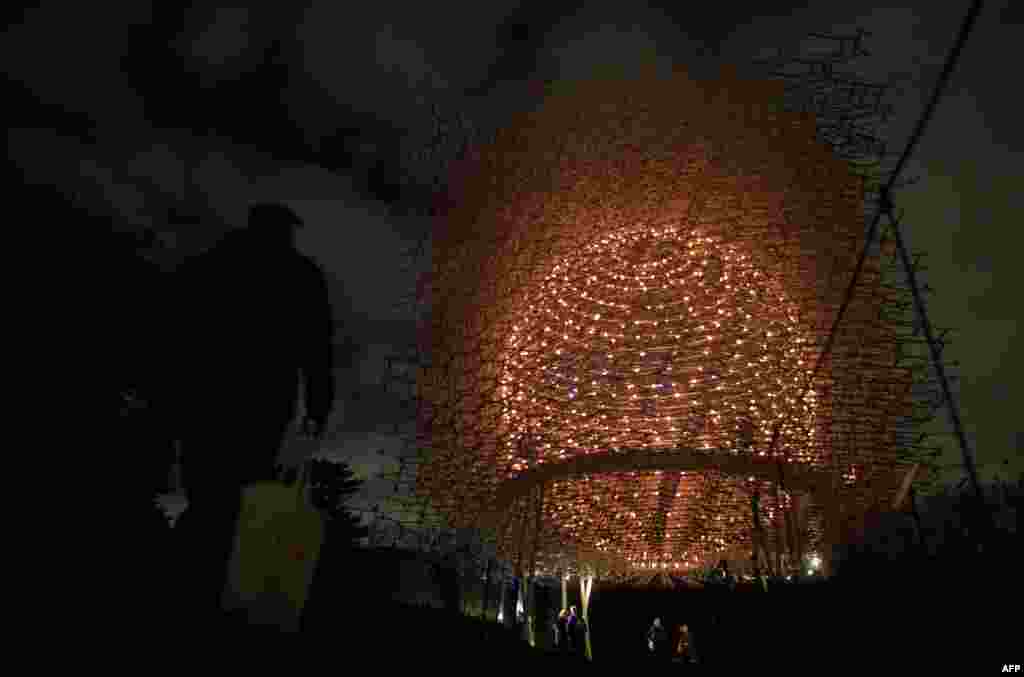 People walk past Wolfgang Buttress' illuminated Hive Installation at Kew Gardens in south London, Nov. 22, 2016.