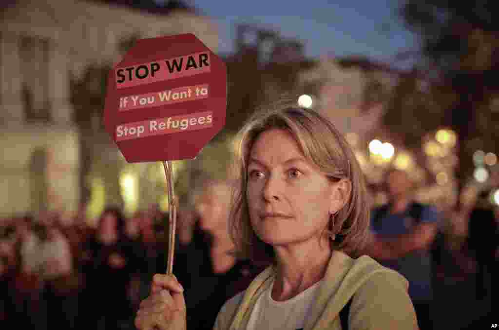 A woman holds a banner during a protest against Hungarian Premier Viktor Orban's policies regarding migrants in Budapest, Sept. 30, 2016.