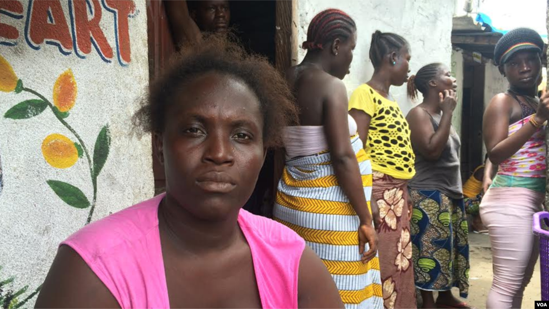 Ebola survivor Finda Fallah sits in front of her new room in West Point, Monrovia, Liberia. As the West African country begins to recover from the crisis, many women are struggling to face a future without their husbands or fathers – the main breadwinners in their families. (Benno Muchler/VOA)