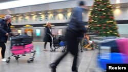 Passengers hurry through the South Terminal building at Gatwick Airport, after the airport reopened to flights following its forced closure because of drone activity, in Gatwick, Britain, Dec. 21, 2018. 