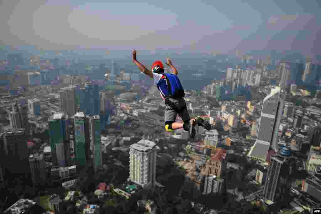 A base jumper leaps from the 300-meter-high skydeck of Malaysia&#39;s landmark Kuala Lumpur Tower during the annual International KL Tower Base-Jump event.