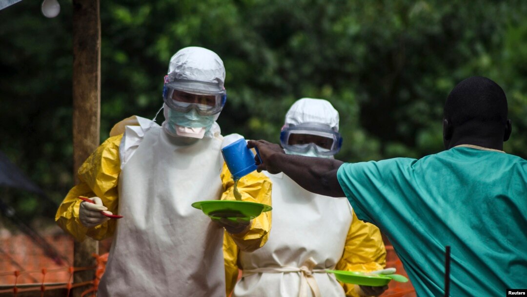 FILE - Medical staff working with Medecins Sans Frontieres (Doctors Without Borders) prepare to take food to patients in the isolation area of an Ebola treatment center in Sierra Leone's Kailahun district, July 20, 2014.
