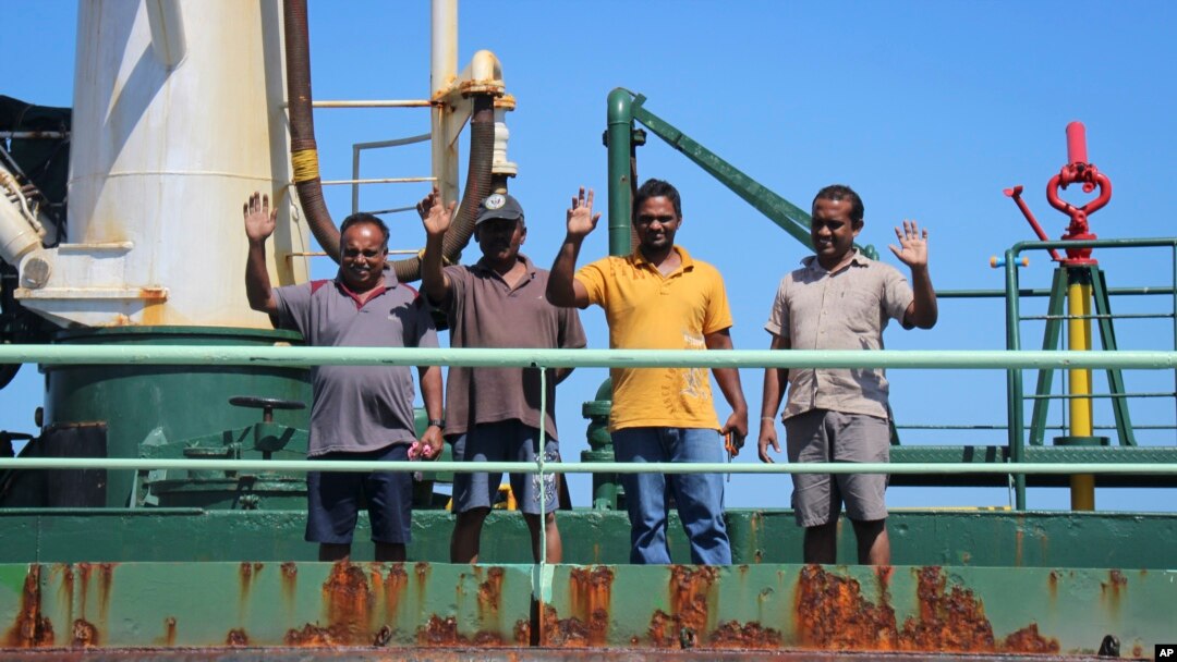 FILE - Crew members wave from aboard the Aris 13 oil tanker, which was released by pirates after negotiations by officials and local elders in Somalia's semiautonomous northeastern state of Puntland, March 19, 2017.