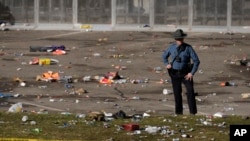 A law enforcement officer looks around the scene following a shooting at the Kansas City Chiefs NFL football Super Bowl celebration in Kansas City, Missouri, Feb. 14, 2024. 