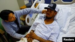 Eduard Caraballo, un migrante venezolano que sobrevivió un incendio en un centro de detención de inmigrantes en Ciudad Juárez, México, recibe la visita de su esposa, Viangly Infante, en un hospital de El Paso, Texas, EEUU, el 3 de abril de 2023. REUTERS/José Luis González