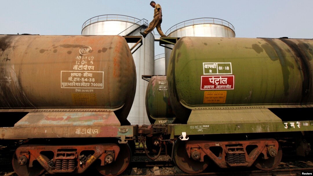 A worker walks atop a tanker wagon to check the freight level at an oil terminal on the outskirts of Kolkata, Nov. 27, 2013. 