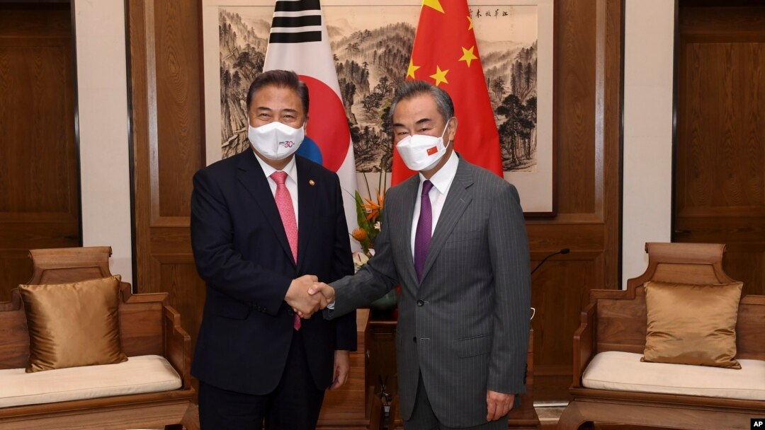 South Korean Foreign Minister Park Jin, left, meets with his Chinese then-counterpart Wang Yi in Qingdao, China, on Aug. 9, 2022. Talks among the foreign ministers of China, South Korea and Japan are expected to take place as soon as this weekend. (Xinhua News Agency via AP)