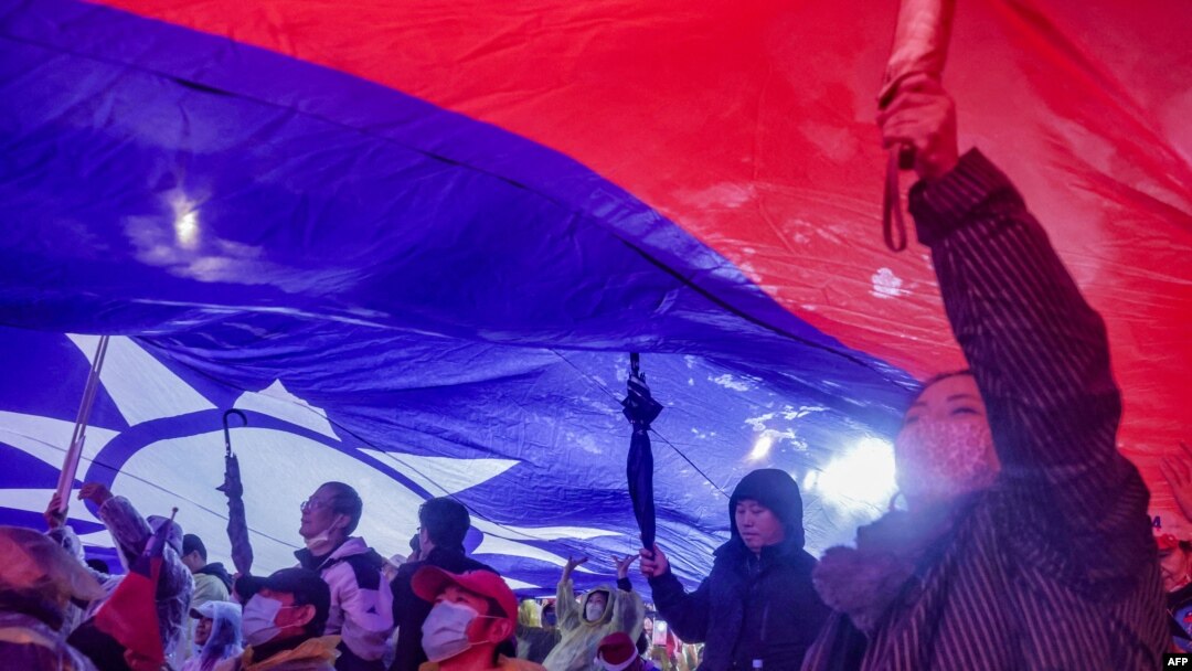 2023年12月23日，在台灣總統大選前的國民黨競選集會上，支持者舉起巨大的台灣國旗。