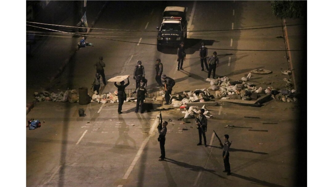 Armed police remove makeshift blockages set up by protesters as they patrol streets in downtown Yangon, Myanmar, March 21, 2021.