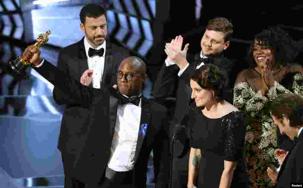 BEST PICTURE: "MOONLIGHT" - Writer and director Barry Jenkins holds up the Best Picture Oscar, following a brief mix-up in which "La La Land" was announced as the winner by presenters. The error was quickly corrected.