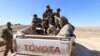 Islamic State fighters sit on a pickup truck while being held as prisoners by fighters of the Syrian Democratic Forces near Ash Shaddadi, Hasakah province, Syria, Feb. 18, 2016.