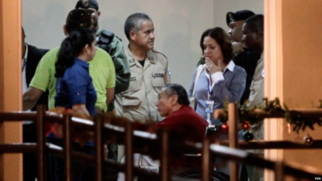 El ex dictador panameño Manuel Noriega en silla de ruedas junto a oficiales de la policía a su llegada a la prisión El Renacer.