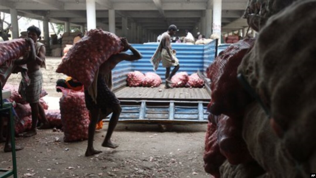 Indian laborers load bags of onions onto a truck in Hyderabad, India ( 2010 file photo)