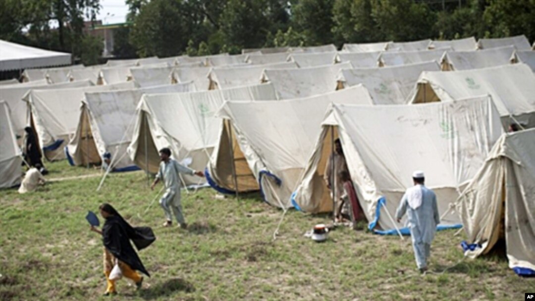 Displaced Pakistanis living a tent camp set up by the army on the outskirts of Nowshera, Pakistan, 2 Aug 2010.