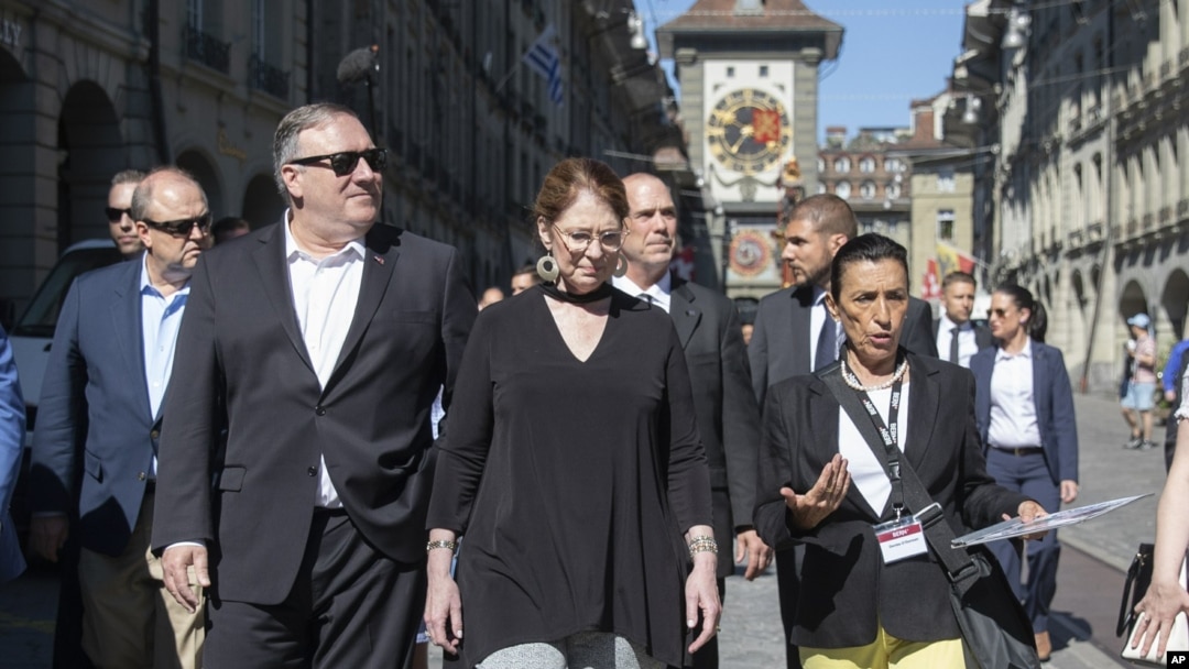El secretario de Estado de los EE. UU., Mike Pompeo, al frente, a la izquierda, y su esposa Suzan, al frente, escuchan a un guía turístico durante un paseo turístico como parte de la visita de Pompeo a Berna, Suiza, el sábado 1 de junio de 2019.