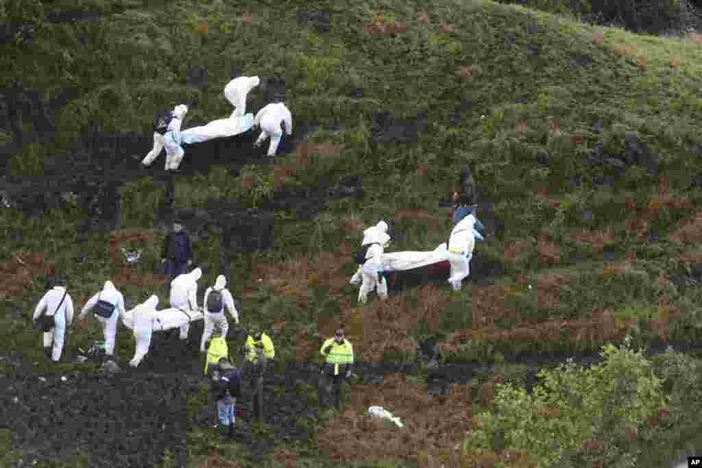Rescue workers carry the bodies of victims of an airplane that crashed in La Union, a mountainous area outside Medellin, Colombia, Nov. 29, 2016. The plane carrying the Brazilian first division soccer club Chapecoense team was on it's way for a Copa Sudamericana final match against Colombia's Atletico Nacional when it crashed.