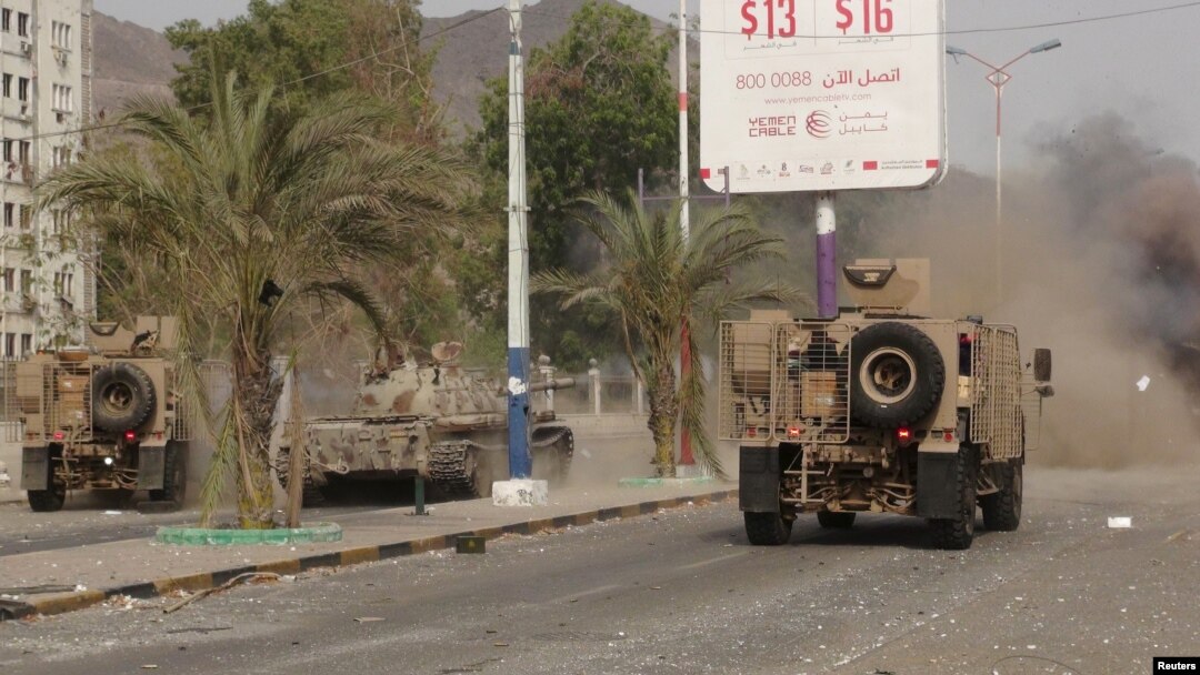 FILE - Military vehicles of the Southern Resistance fighters move during clashes with Houthi fighters on a street in Yemen's southern port city of Aden, July 17, 2015.