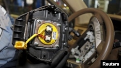 FILE - A recalled Takata airbag inflator, removed from a Honda Pilot, is shown at the AutoNation Honda dealership service department in Miami, Florida, June 25, 2015. 