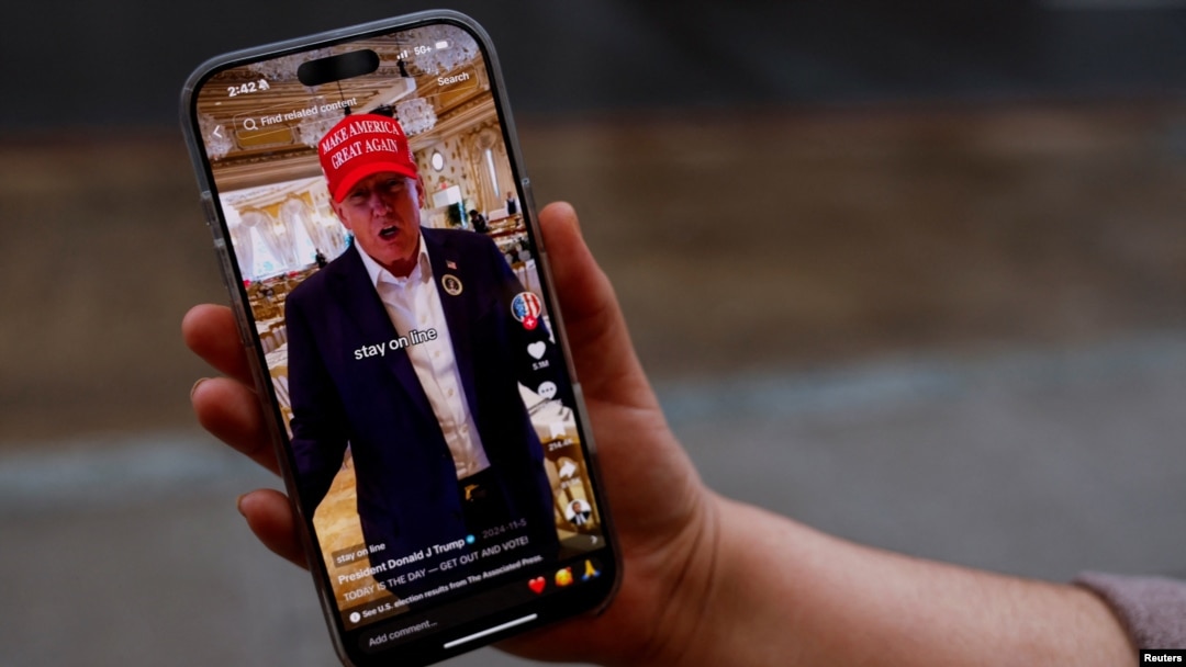 A woman poses with her smartphone displaying the @realdonaldtrump TikTok page, in Washington