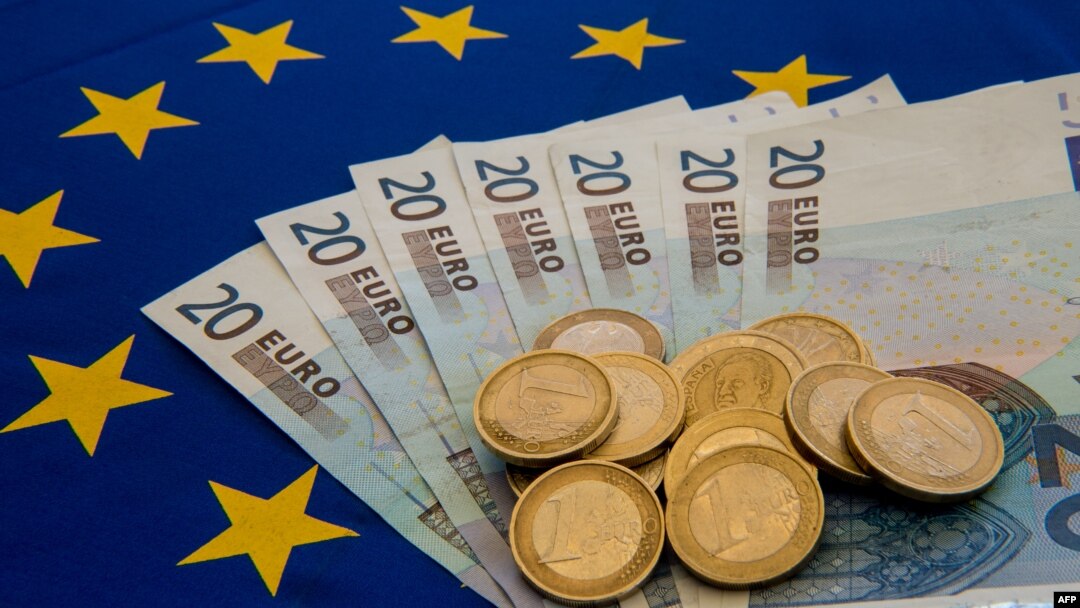 A picture taken on June 29, 2015 in Lille shows Drachma bills, Greece's former currency, next to euro bills and coins.