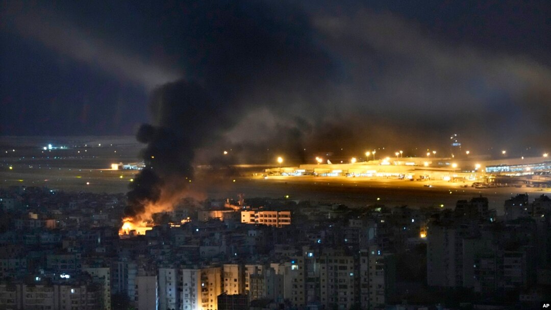 Flames and smoke rise from an Israeli airstrike, as Rafik Hariri international airport is seen in the background, in the southern suburbs of Beirut, Lebanon, Oct. 20, 2024. 