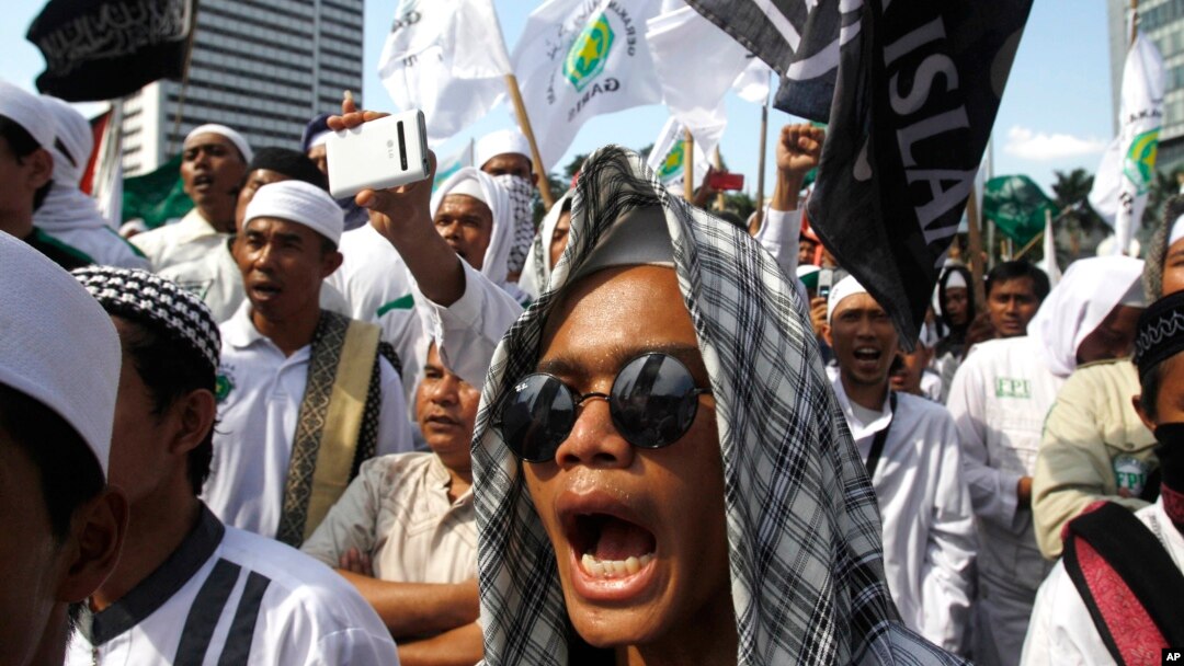 FILE - Members of the militant Islamic Defenders Front (FPI) shout slogan during a demontration in Jakarta, Indonesia.