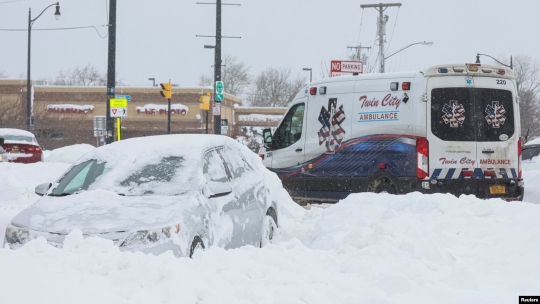 An ambulance passes an abandon car during a winter storm that hit the Buffalo region, in Amherst, New York, Dec. 26, 2022. 