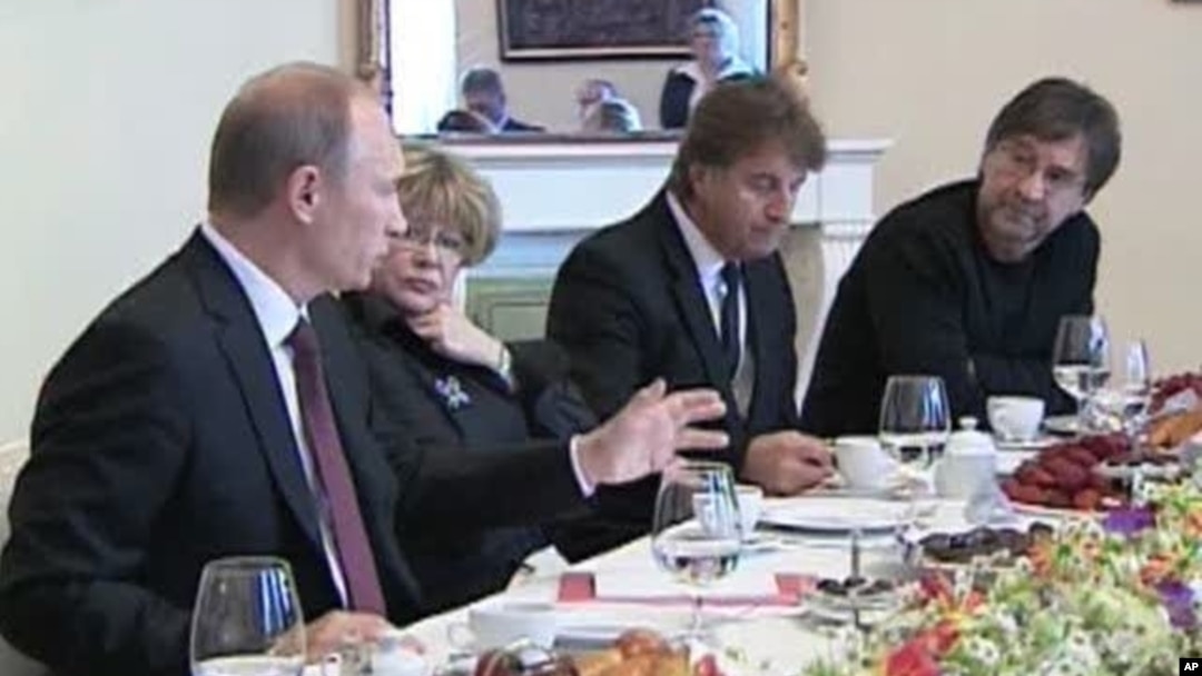 Russian Prime Minister Vladimir Putin, left, responds to questions from rock musician Yuri Shevchuk, right